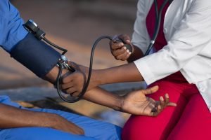 An african doctor checking the blood pressure of a patient
