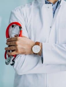 Young handsome physician in a medical robe with stethoscope