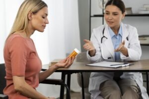 A doctor talking to a patient who is holding a bottle of medicine for Hormone Replacement Therapy
