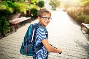 A boy riding a bicycle, looking back and smiling