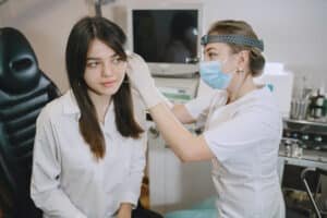 A female doctor thoroughly examining and analyzing Ear Infection of a female patient